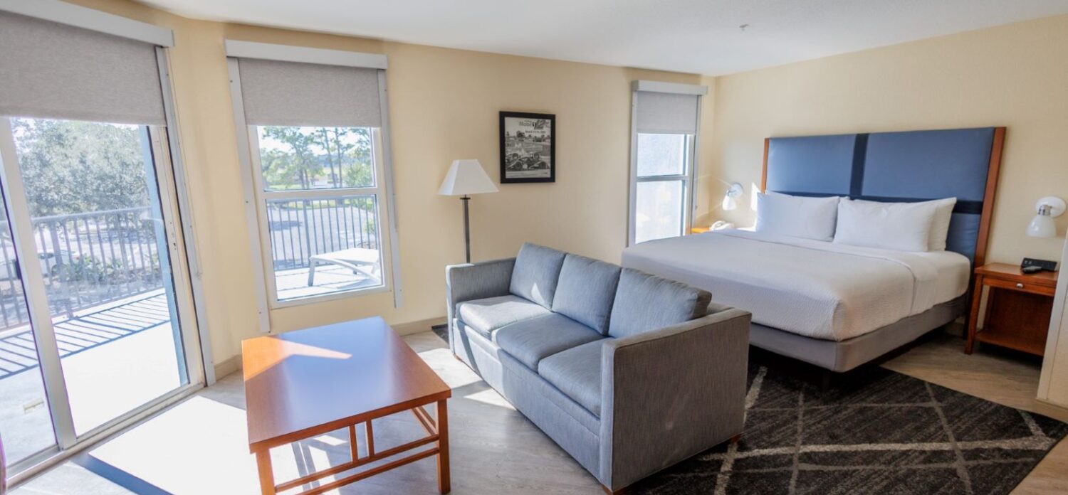 bedroom with bed, couch, coffee table, balcony door
